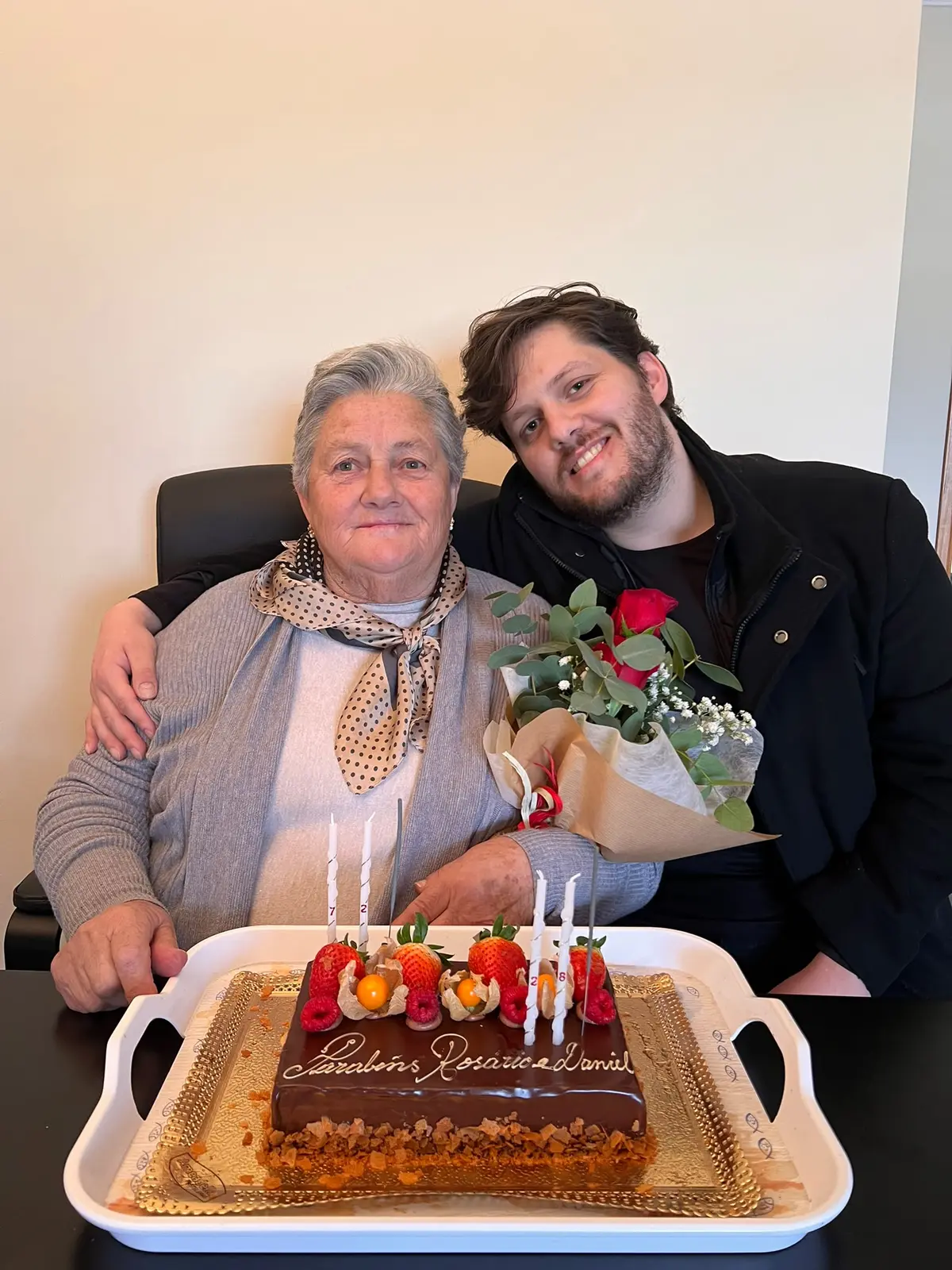 Fábio Daniel e a mãe sentados lado a lado num aniversário
